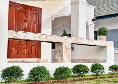 Front entrance of a house with plants and a lawn