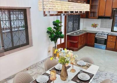 Modern kitchen and dining area with set table and chandelier