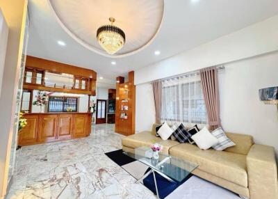 Well-lit modern living room with chandelier and marble flooring