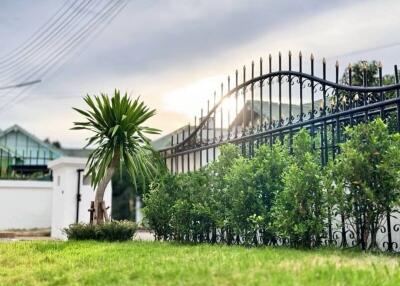 Beautiful garden with a well-maintained lawn and an elegant metal fence