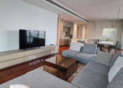 Modern living room with a TV and a view into the kitchen