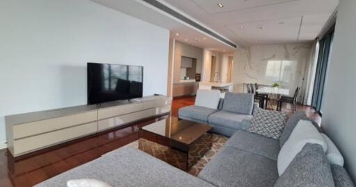 Modern living room with a TV and a view into the kitchen