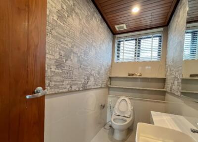 Modern bathroom with wooden ceiling and patterned wallpaper