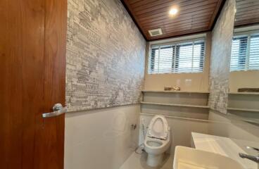 Modern bathroom with wooden ceiling and patterned wallpaper