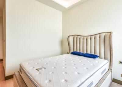 Well-lit bedroom with bed and upholstered headboard