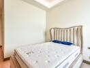 Well-lit bedroom with bed and upholstered headboard