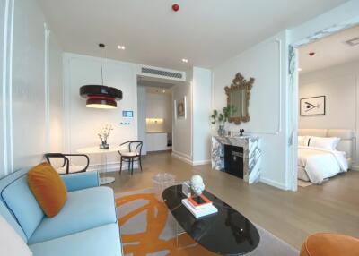 Modern living room with adjoining dining area and view into bedroom