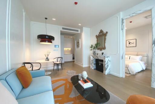 Modern living room with adjoining dining area and view into bedroom