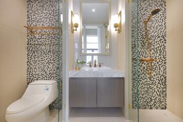 Modern bathroom with mosaic tile walls and glass shower enclosure