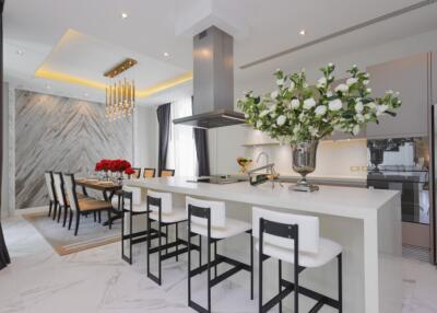 Modern kitchen and dining area with white countertops and elegant decor