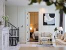 Elegant living room with marble fireplace, staircase, and view into a bedroom