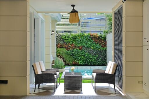 Covered outdoor patio area with seating and pool view