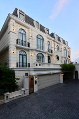 Elegant multi-story residential building with a paved driveway