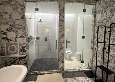 Luxurious marble bathroom with separate shower and toilet areas