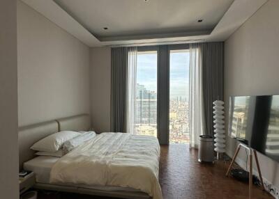 Spacious bedroom with large windows and city view