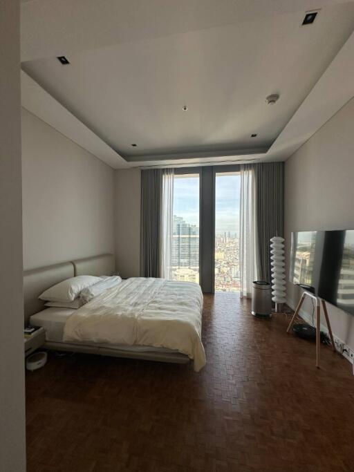 Spacious bedroom with large windows and city view