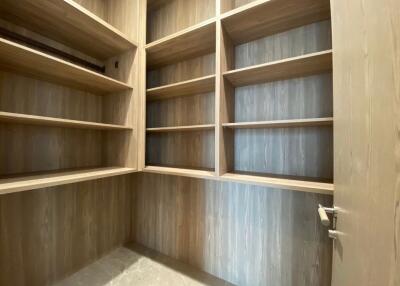 Spacious walk-in closet with ample wooden shelving