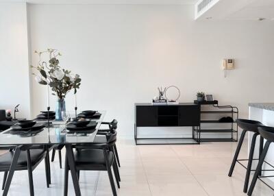 Modern dining area with glass-top table and black chairs