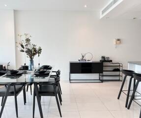 Modern dining area with glass-top table and black chairs