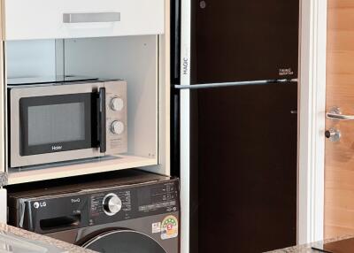 Kitchen appliances including microwave, refrigerator, and washing machine