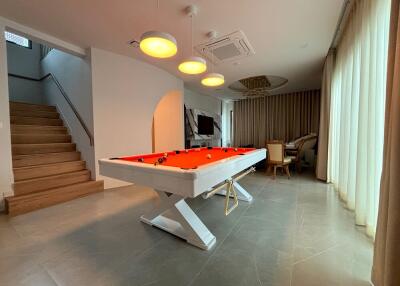 Living area with pool table and staircase