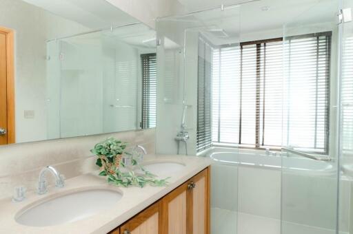 Modern bathroom with double sinks and glass shower