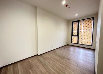 Empty living room with large windows and wooden floors