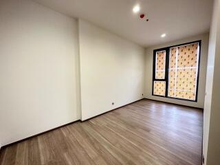 Empty living room with large windows and wooden floors