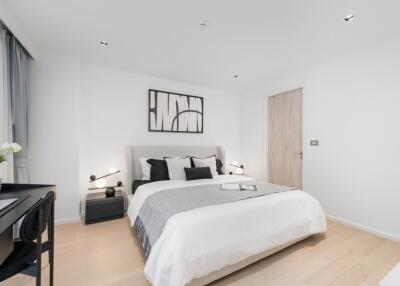 Modern bedroom with a double bed, bedside tables, and a writing desk