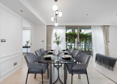 Modern dining area with large windows and a view of greenery