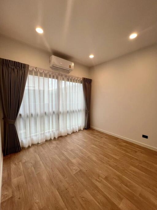 Spacious living room with wooden flooring and natural light