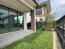 View of a home's backyard with a small lawn and a patio