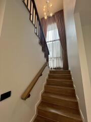 Interior staircase with wooden steps and large window