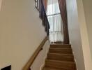 Interior staircase with wooden steps and large window