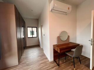 Small bedroom with a wardrobe, desk, and air conditioning unit