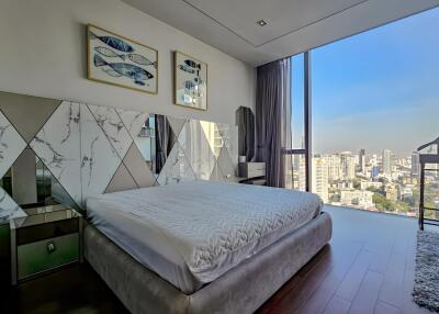 Modern bedroom with a large window and city view