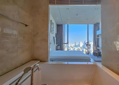 Modern bathroom with a view of a bedroom and cityscape