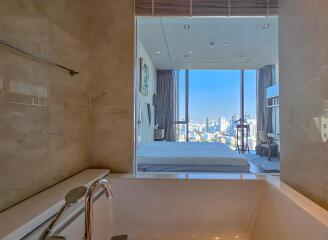 Modern bathroom with a view of a bedroom and cityscape