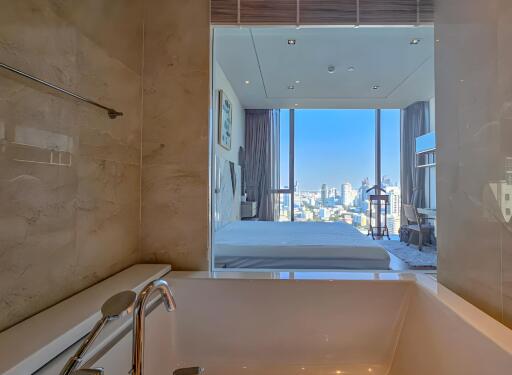 Modern bathroom with a view of a bedroom and cityscape