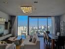 Modern living room with city view, chandelier, and dining area