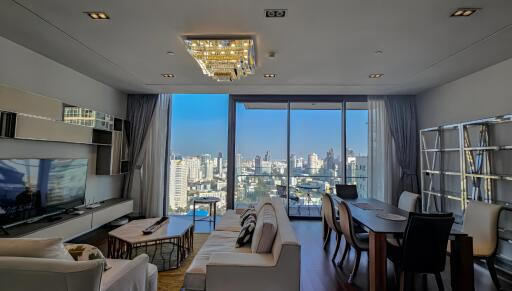 Modern living room with city view, chandelier, and dining area