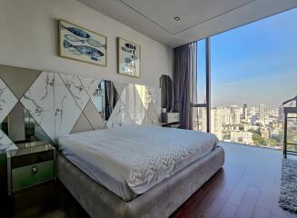 Modern bedroom with large windows and city view