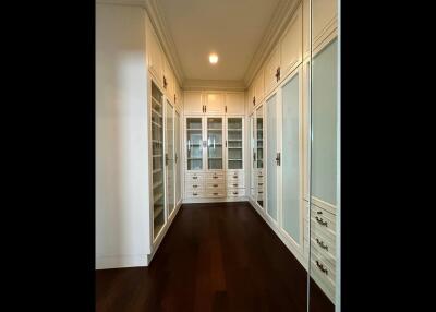 Spacious walk-in closet with built-in shelves and cabinets