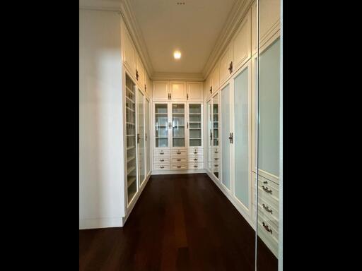 Spacious walk-in closet with built-in shelves and cabinets