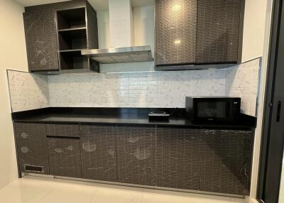 Modern kitchen with dark cabinets and white backsplash