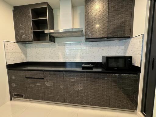 Modern kitchen with dark cabinets and white backsplash