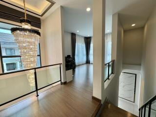 Elegant hallway with a chandelier and wooden flooring