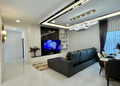 Modern living area with sectional sofa, TV, and dining space