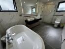 Modern bathroom with a large bathtub, double sink, and glass shower