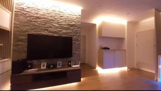 Modern living room with stone accent wall and ambient lighting